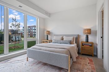 a bedroom with a bed and a large window